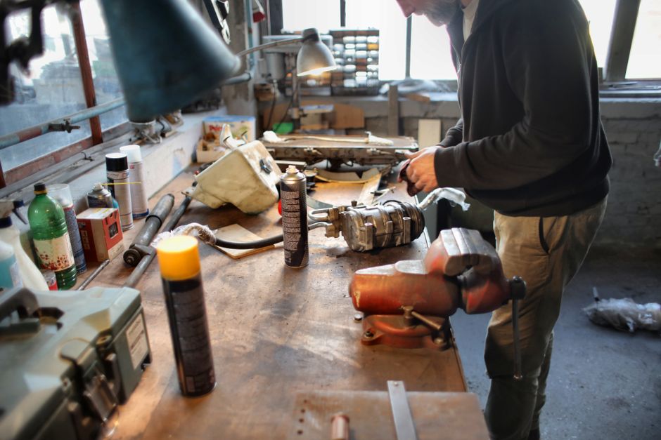 A skilled mechanic repairing machinery in a well-equipped workshop.
